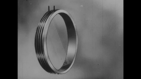 1940s: Magnet rotates inside coil. Voltmeter attached to coil. Stock Footage 123020377
