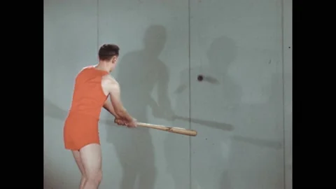1940s: Man with bat hitting ball on string. Intertitle. Man hits ball. 库存影片 168263328