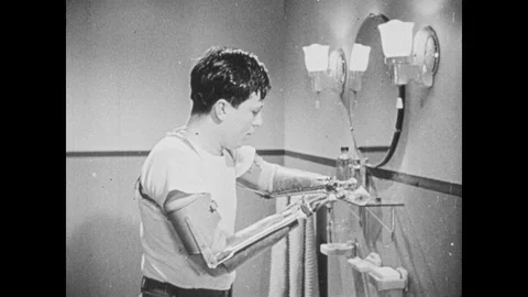 1940s: Man brushes teeth.  Double amputee uses hooks to fasten belt. Vídeo Stock 89815527