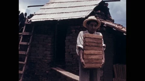 1940s: Man carrying stack of bricks. Intertitle. Pan across painted tiles. Pan Stock Footage 167182585