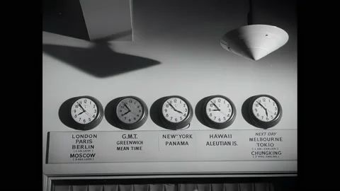 1940s: Man checks news from teletype machines.  Clocks show times around the Stock Footage