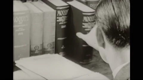 1940s: Man at desk pulls book from stack. Man reading. Girl pulls book from 스톡 동영상 161805106