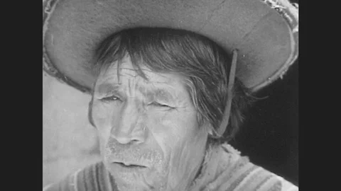 1940s: man in hat chews coca leaves and watches boy pull leash on llama past Stock Footage 79975195