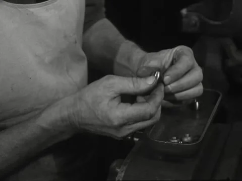 1940s: Man inspects small round machine parts Video stock 231725732