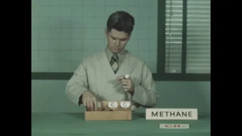 1940s: A man in a lab coat demonstrates the structure of methane using a Stock Footage 280687935