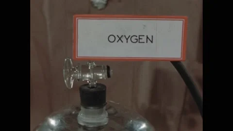 1940s: Man in lab holding up test tube. Writing on paper. Label on tank, hand Stock Footage 172025547