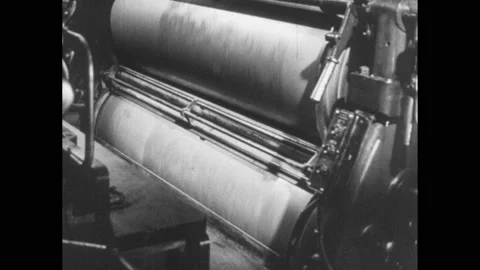 1940s: Man monitors large offset printing press. Paper runs through machine, Man Видео 152533216