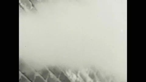 1940s: Man pulls lever.  Smoke.  Man drags co-worker to safety.  Man shuts door. Stock Footage 155116575