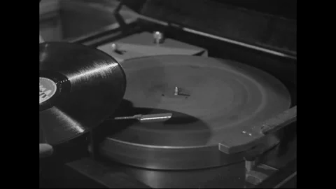 1940s - A man puts a record on a 78 rpm record player and plays it. Stock Footage 126053239