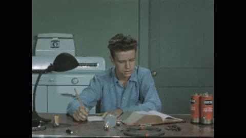 1940s: man snaps clapperboard by actor’s head. Batteries on kitchen table. Boy Stock Footage 195118552