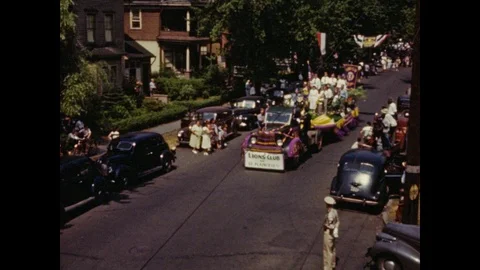 1940s: Marching bands, floats pass along residential street in 4th of July Video stock 107158154