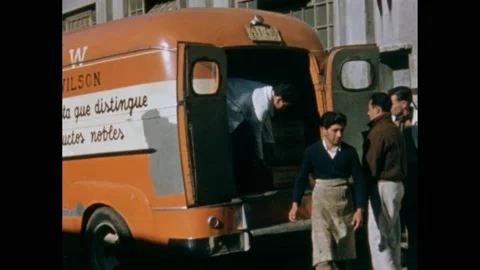 1940s: Men load boxes onto truck. Worker uses forklift to carry parcels. Stockbeeldmateriaal 224170848