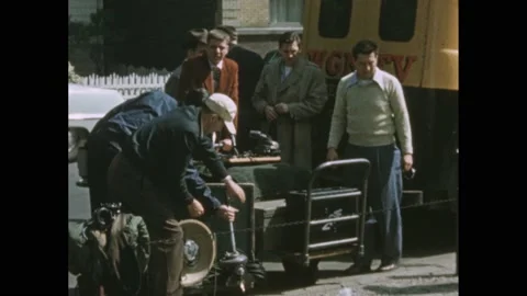 1940s: Men load things onto carts and pull.  News truck pulls up to curb.  Man Stock Footage 238792282