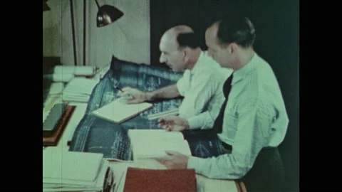 1940s: Men talk and work on blueprint at drafting table. Pearl Harbor attack Stock Footage 140916113