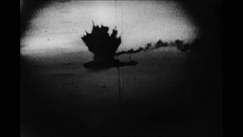 1940s: Ocean.  Ship explodes.  Debris in water.  Body.  Person on piece of Vídeos de archivo 167370393