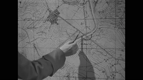 1940s: Officer points at map with pencil. Nazi officers speak. Stock Footage 148158152