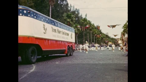 1940s: Parade of Navy bus, marching band, and colorful floats bearing costumed Stockbeeldmateriaal 86660871