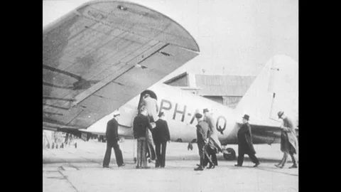 1940s: People enter plane. Crowd at airport cafe. Men in uniform wave. Plane Stock Footage 78069814