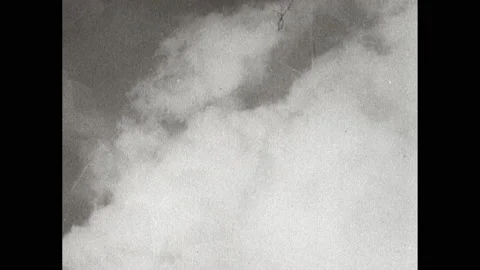 1940s: Pilot in cockpit. Bombs fall from plane. Smoke rises from city. Stock Footage 152534567