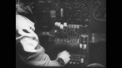 1940s: Pilot in cockpit, hands working controls. Aerial shot, plane wing over Stock Footage 152534209