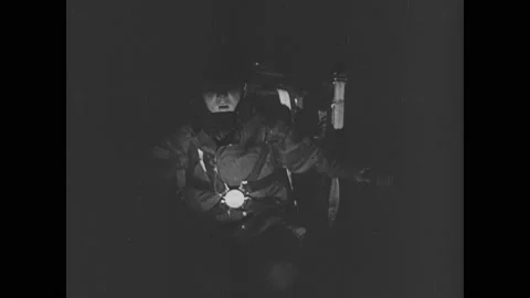 1940s: Pilot in plane, hand on switch. Light for soldiers to parachute goes on. Stockbeeldmateriaal 150347761