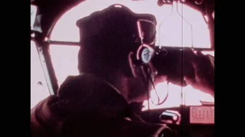 1940s: Pilot in plane looks through binoculars. Seaplane flies over Navy ships Stock Footage 133254910