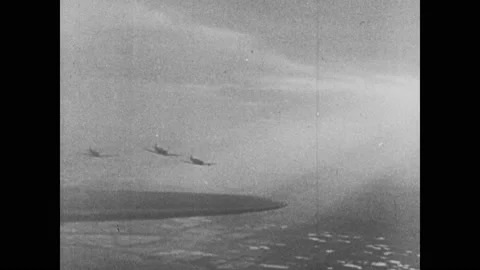 1940s: Plane drops bombs. Bombs explode near ship. Planes fly through sky. Plane Video stock 146148582