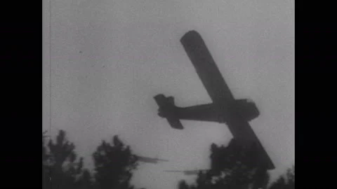 1940s: Plane lands in field, flips over. Planes fly through sky. Soldiers jump Stock Footage 137411862