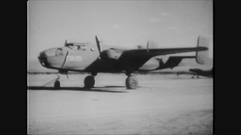 1940s: Plane on runway. Soldiers pulling rockets on cart. Men attach rocket to 스톡 동영상 128193563