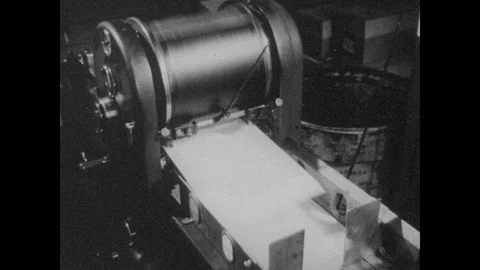 1940s: Printing press. Man hands out flyers. Hand puts document on table, hand Видео 88641885