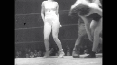 1940s: Referee separates lady wrestlers. Wrestlers grapple and perform arm bar. Vídeo Stock 160573391