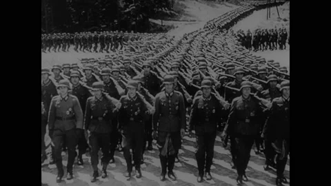 1940s: Rows of marching soldiers converge into one line.  Map.  Mountains.  Man Stock Footage 147602789