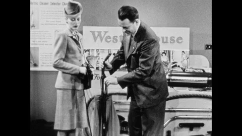 1940s: Salesman plugs in vacuum cleaner. Salesman speaks to woman. Salesman Stock Footage 90524086