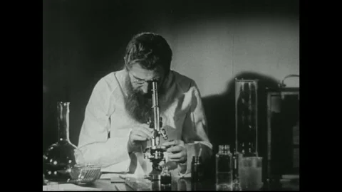 1940s. Scientist in laboratory looks into microscope. Two scientists work in Stock Footage 74668019