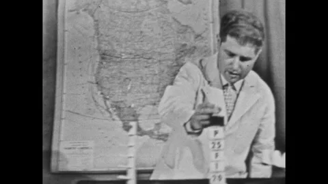 1940s: Set.  Men walk to table.  Men speak.  Men stack blocks on holder. Stock Footage 243365885