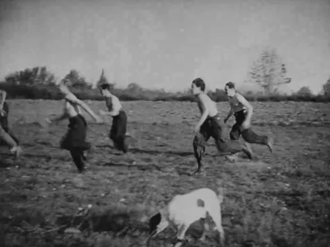 1940s: Shirtless boys doing pushups in field Stock Footage 229735328