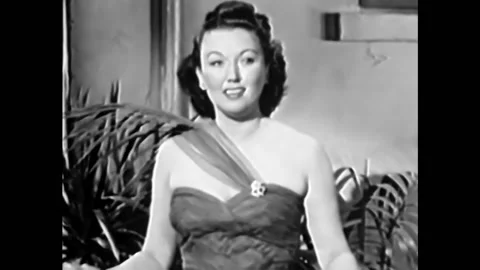 1940s - Singer Ginny Simms begins a performance of "I Don't Stand a Ghost of a Video stock 246364524