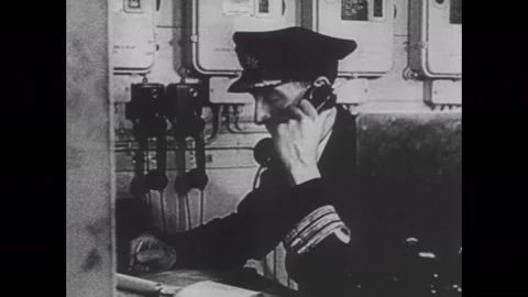 1940s: Soldiers operate ship's controls. Ships depart from ports. Ships travels Stock Footage 137411953