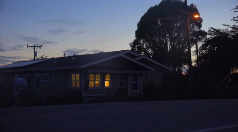A 1940's style house with the lights on at night. Stock Footage