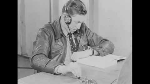 1940s: A stylish man in a leather jacket and headphones listens and taps on a Video stock 156514155