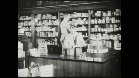 1940s: Teacher instructs pharmacy students in lab. Student assists pharmacist in Stock Footage