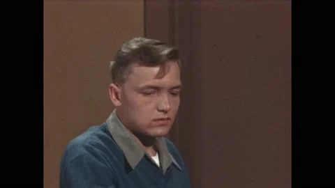 1940s: teenager answers question in interview. Boy looks sad. Man interviews Stock Footage