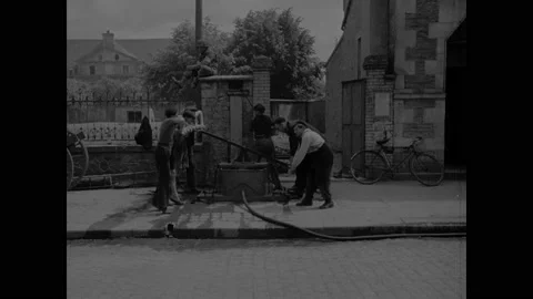 1940s: Text reads "INV. 132."  City.  Men pump water at town well.  Firefighter Vidéo 148226574