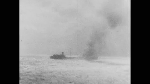 1940s: Text: Sea War: British destroyer sinks German ships. German ship on fire, Stock Footage 232949242