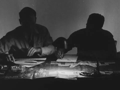 1940s: Two engineers work by desk lamp Video stock 229441343