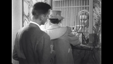 1940s: UNITED STATES: lady works behind bars. People buying cars. Man with bike. Stock Footage