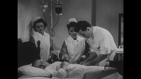 1940s: UNITED STATES: nurses help with blood transfusion. Doctor talks with Vidéo 122302564