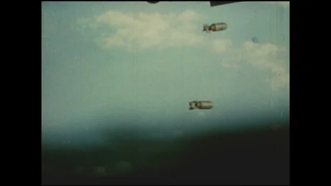 1940s: UNITED STATES: side view of plane in sky. Bombs drop from plane. View of Stock Footage 91865552