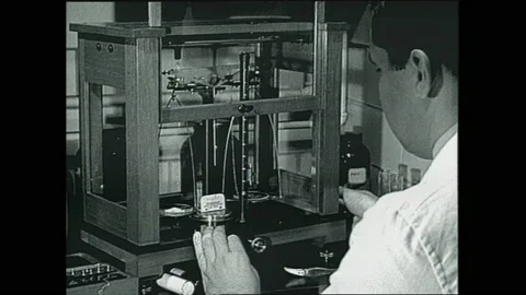 1940s: View of sign. Man in lab. Hands moving equipment. Man using blow torch. Stock Footage 153553842