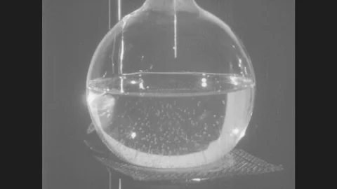 1940s: Water in flask, tiny bubbles begin to form. Thermometer goes from 50 Stock Footage 80382575